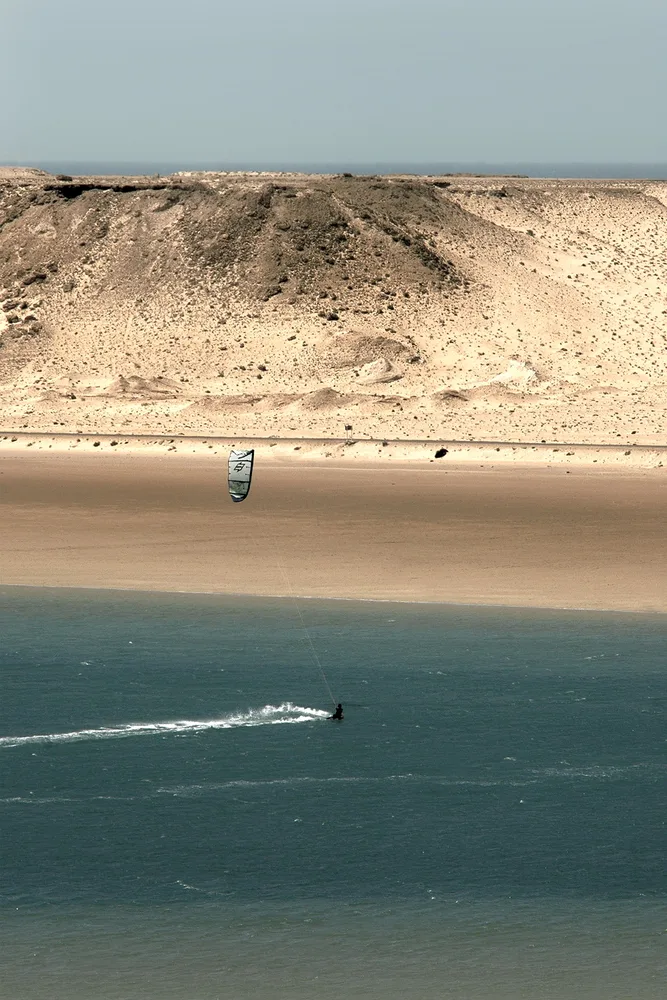 Kitesurfeur sur la lagune de Dakhla vu depuis la hauteur, plage déserte et dunes