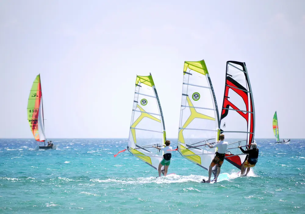 Groupe de windsurfeurs naviguant ensemble sur un plan d'eau