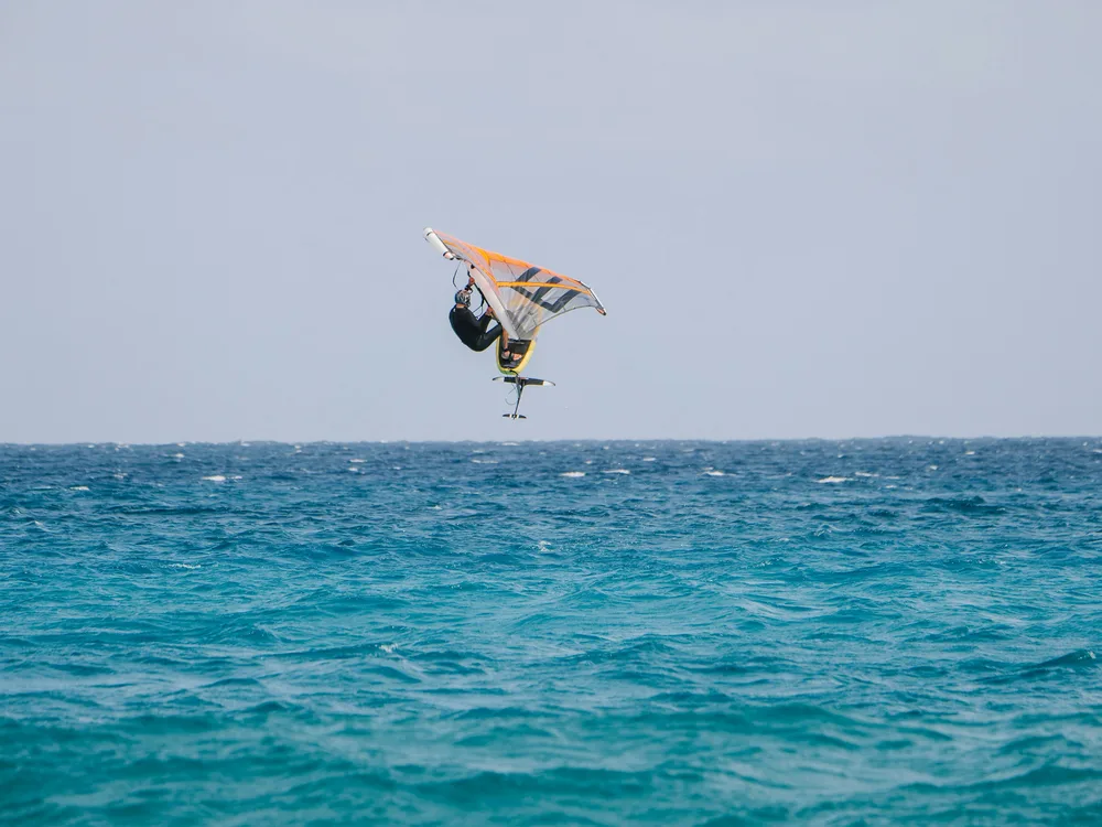 Wing foiler au-dessus d'une mer turquoise sur un spot tropical