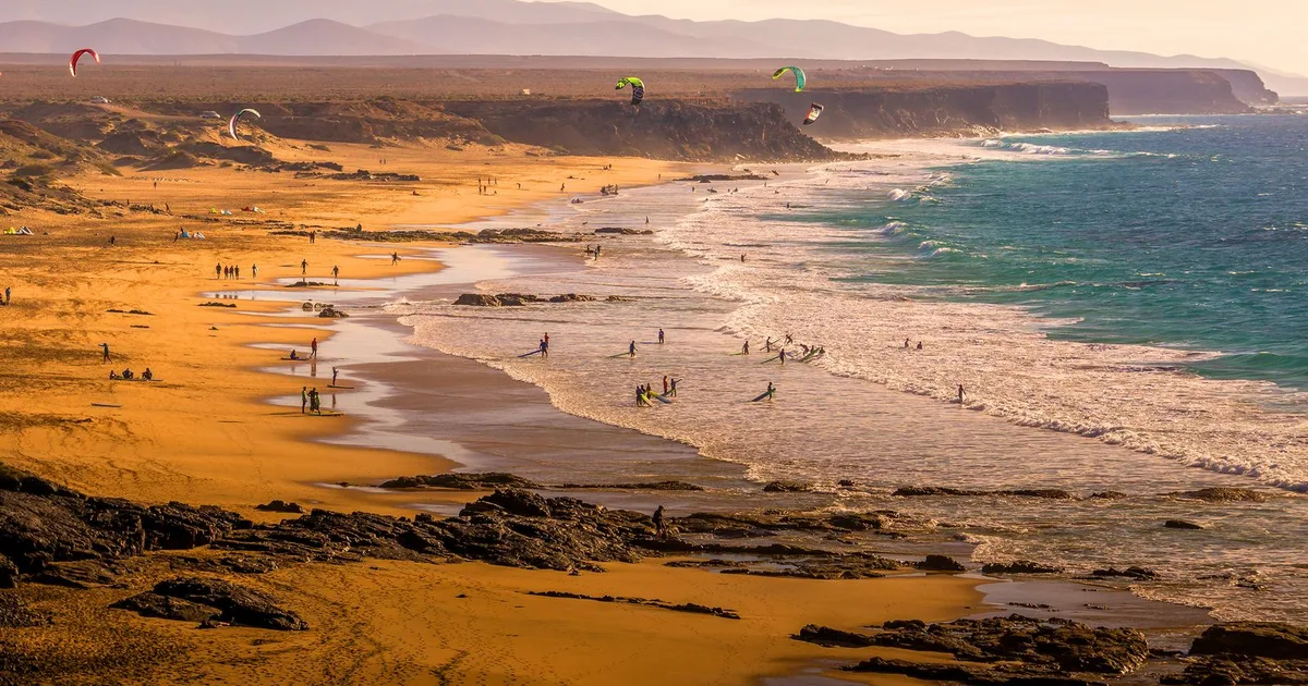 Kitesurfeurs sur une plage de Fuerteventura au coucher du soleil