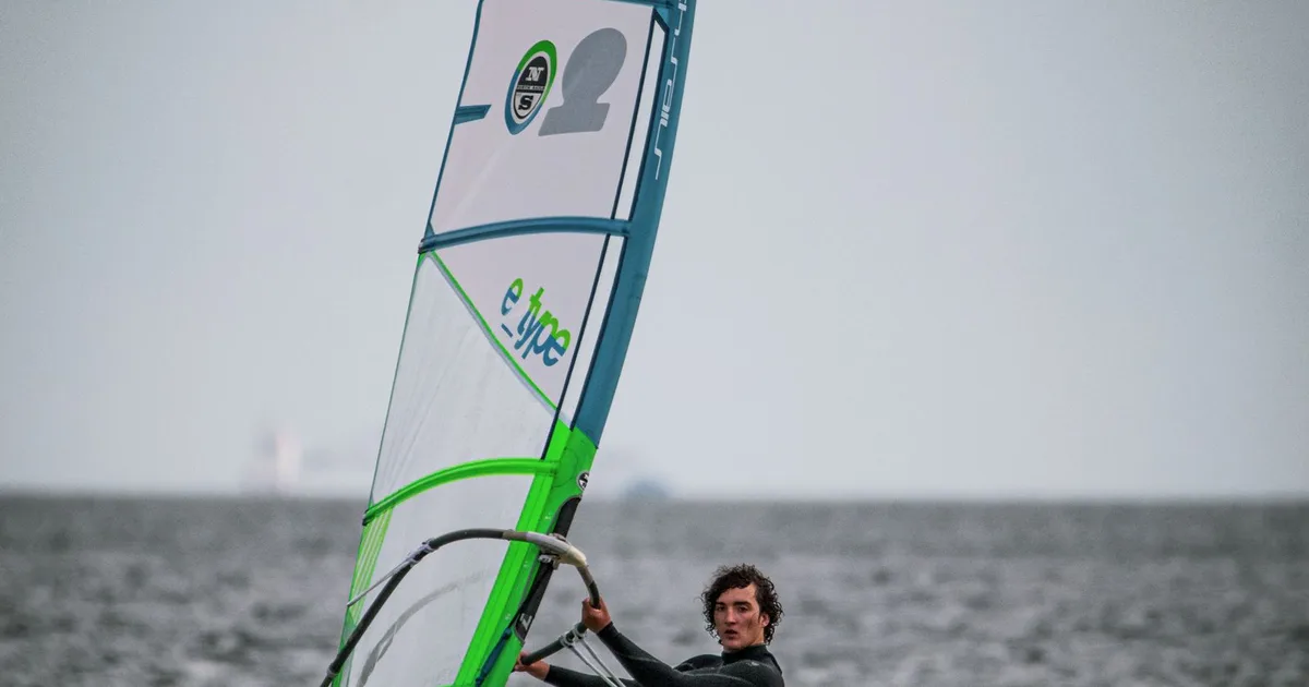 Windsurfeur au planning par vent soutenu, combinaison intégrale