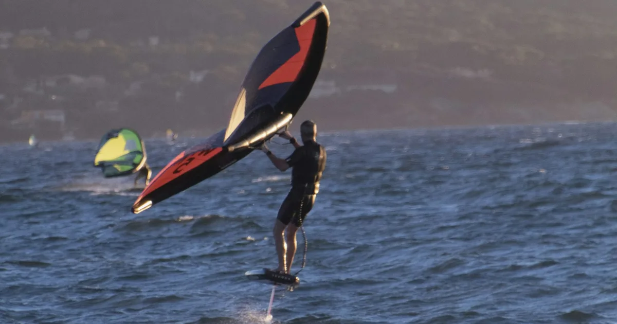 Wing foiler en Méditerranée par mer agitée au coucher du soleil